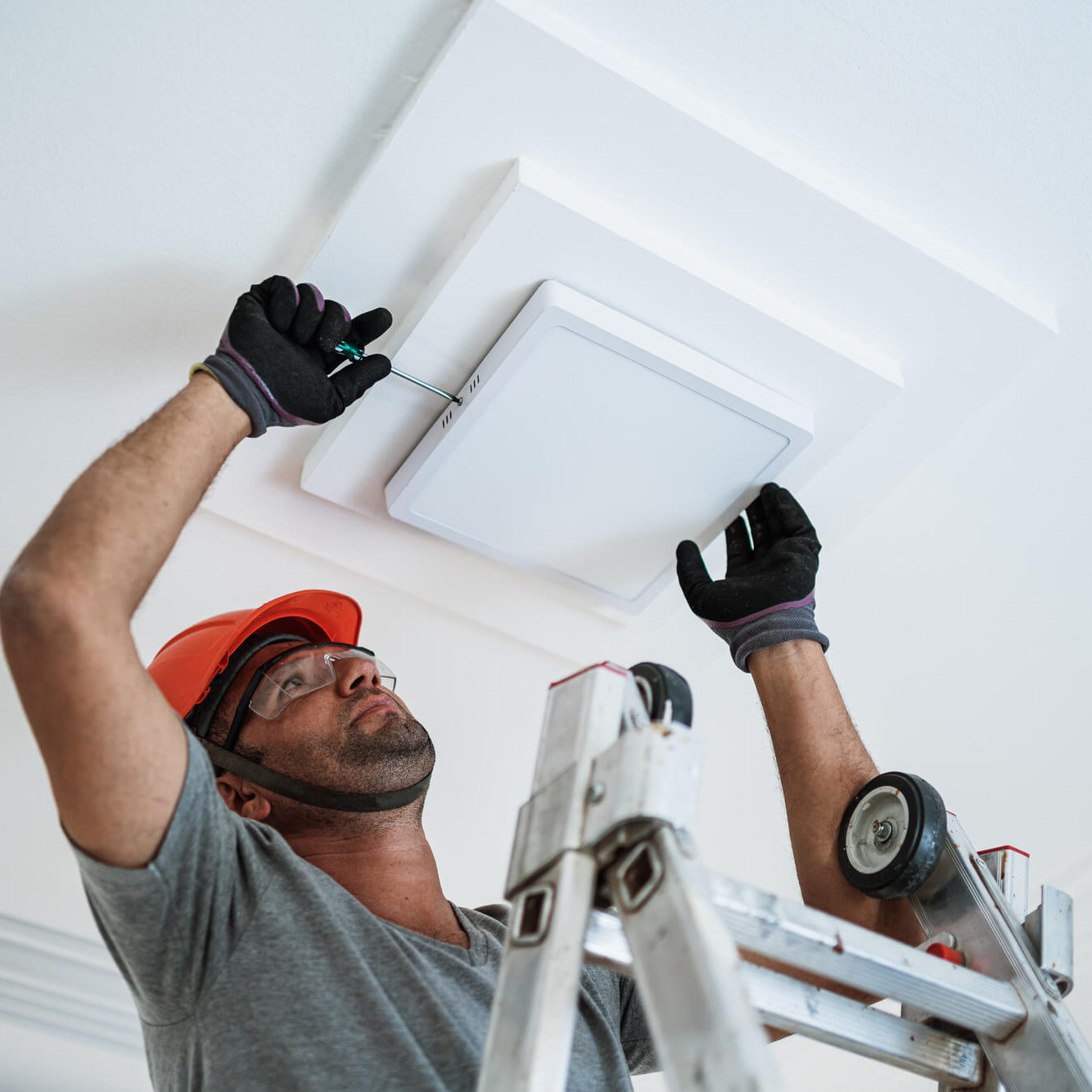 A man is fixing the ceiling light.