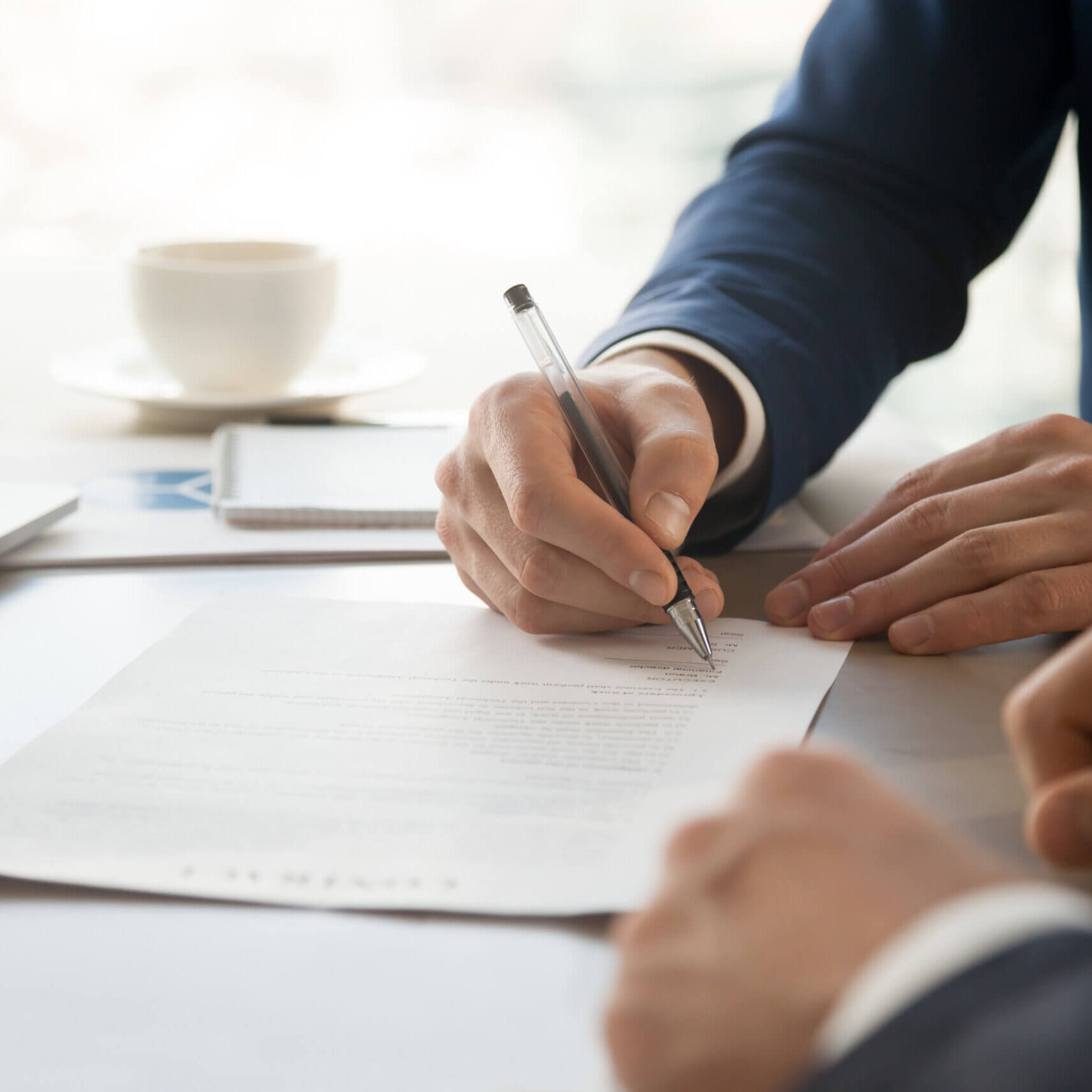 Businessman accepting business partners offer Close up image of businessman hand putting personal signature on contract document in presence of business partner. Starting successful partnership with entrepreneur or companie, making good deal