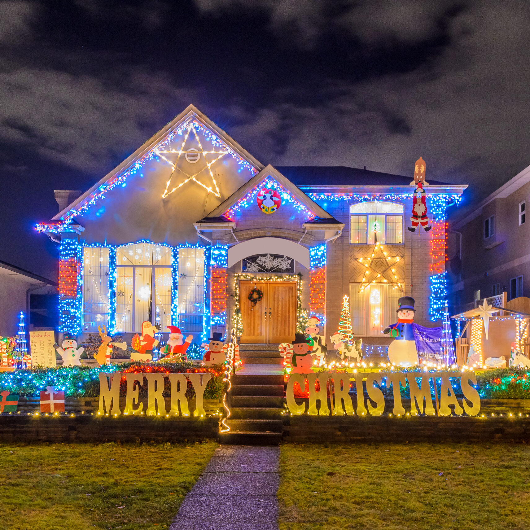 A White house adorned with a colorful array of Christmas lights and the heartwarming words "Merry Christmas," creating a joyful and festive ambiance.